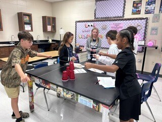 Students cooperatively working to stack cups