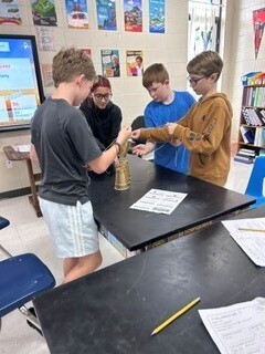 Students cooperatively working to stack cups