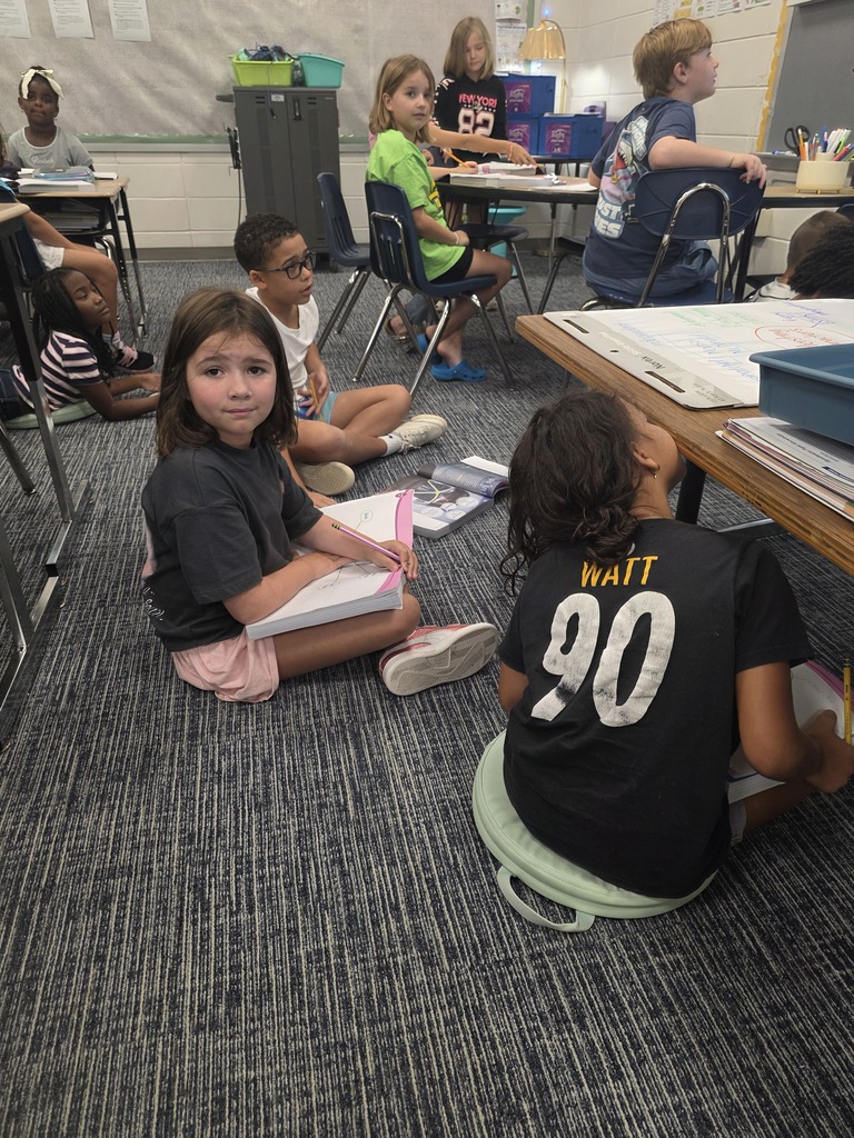 Third-grade students in Mrs. Villanueva’s class discuss character traits during a group reading lesson.