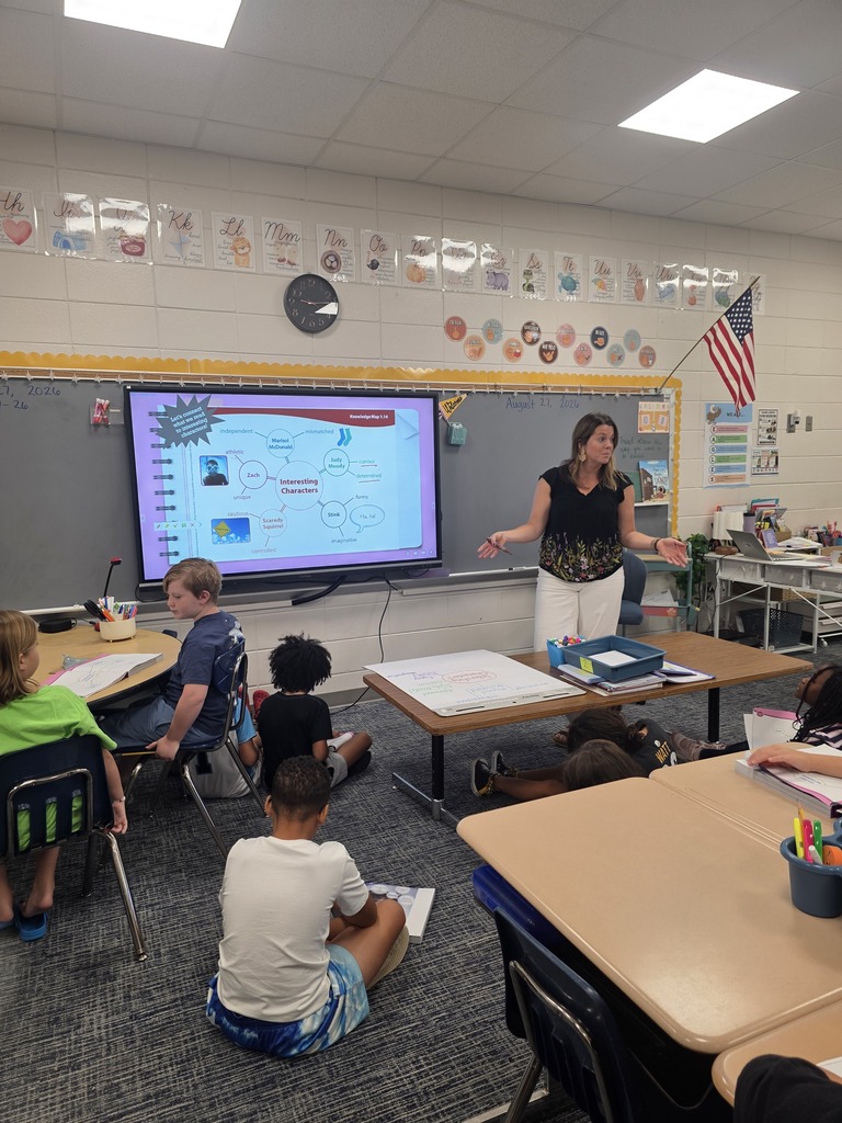 Third-grade students in Mrs. Villanueva’s class discuss character traits during a group reading lesson.