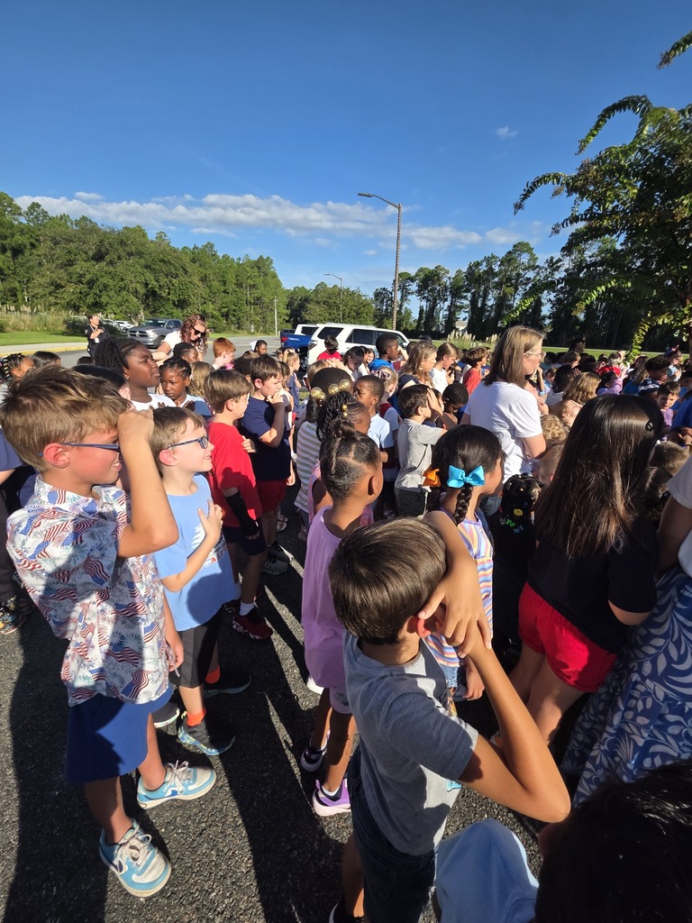 Sugarmill Elementary students partnered with local military members to honor 9/11 by singing "God Bless the U.S.A." by Lee Greenwood and clapping as the flag was raised to half-staff following a guest service member's lesson on its solemn meaning.