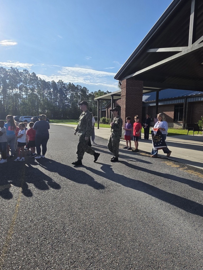 Sugarmill Elementary students partnered with local military members to honor 9/11 by singing "God Bless the U.S.A." by Lee Greenwood and clapping as the flag was raised to half-staff following a guest service member's lesson on its solemn meaning.