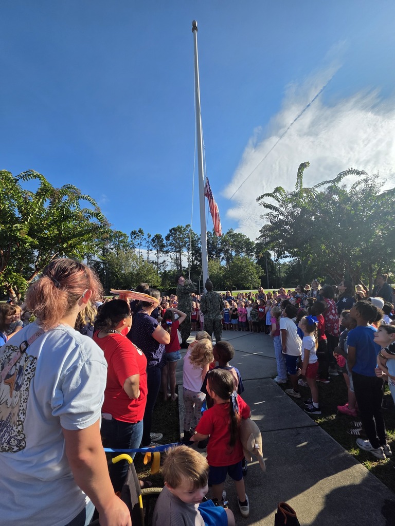 Sugarmill Elementary students partnered with local military members to honor 9/11 by singing "God Bless the U.S.A." by Lee Greenwood and clapping as the flag was raised to half-staff following a guest service member's lesson on its solemn meaning.