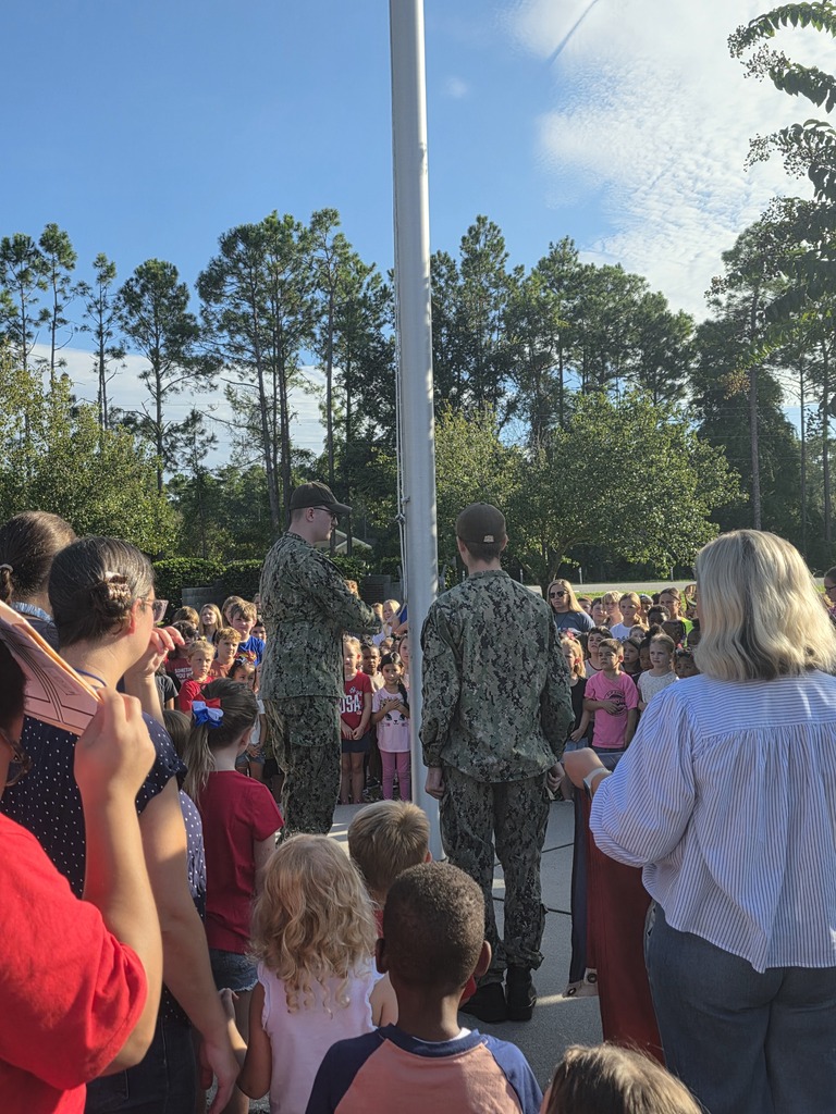 Sugarmill Elementary students partnered with local military members to honor 9/11 by singing "God Bless the U.S.A." by Lee Greenwood and clapping as the flag was raised to half-staff following a guest service member's lesson on its solemn meaning.