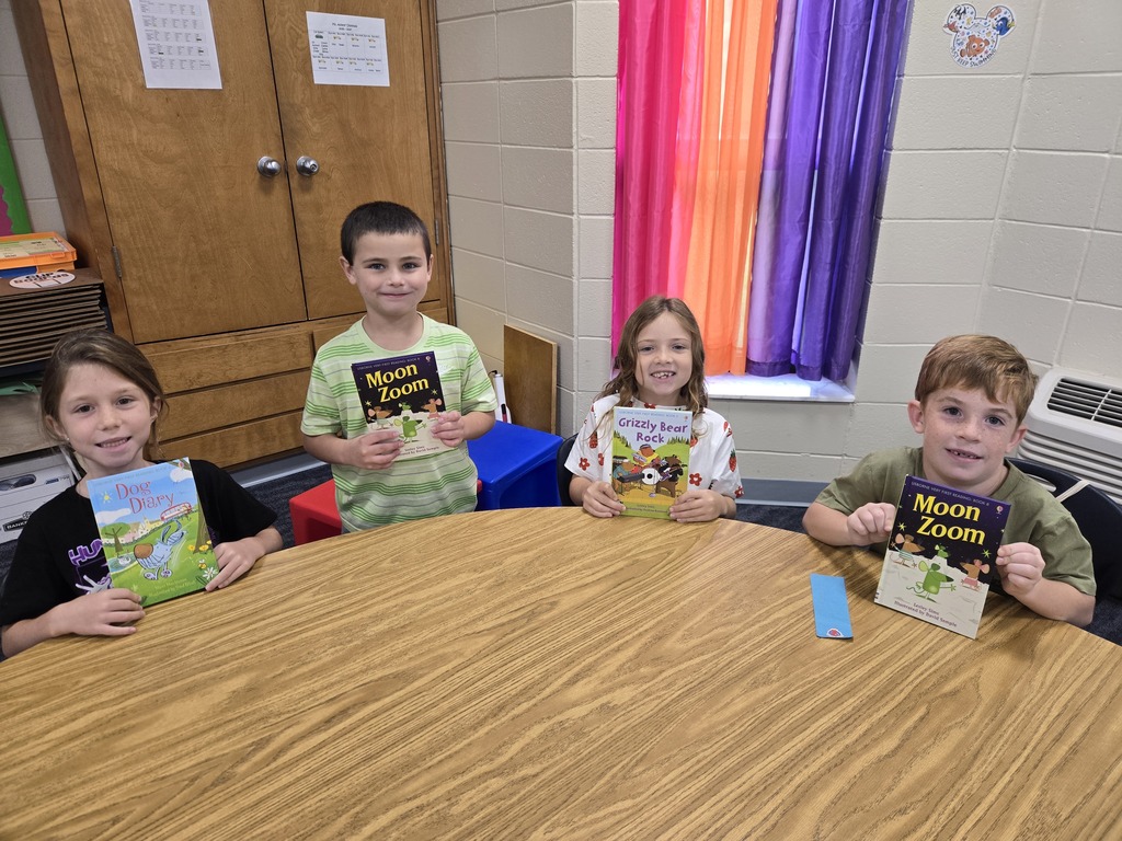 First graders holding up their new book!