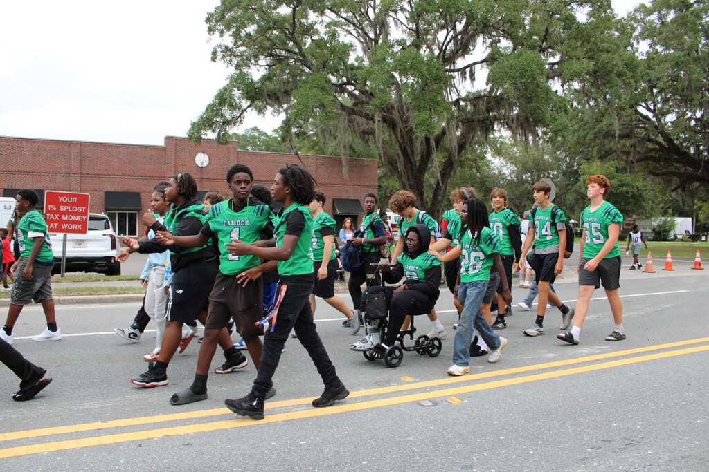 Football team marching in the homecoming parade