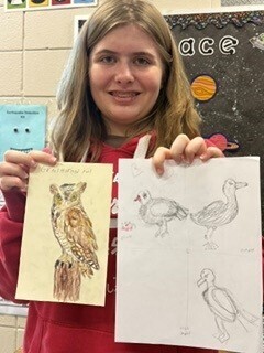Bessette's Bird Club student photo holding up artwork