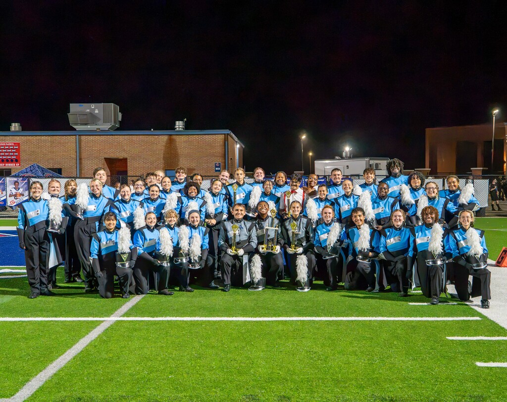marching band leaders posing with trophies