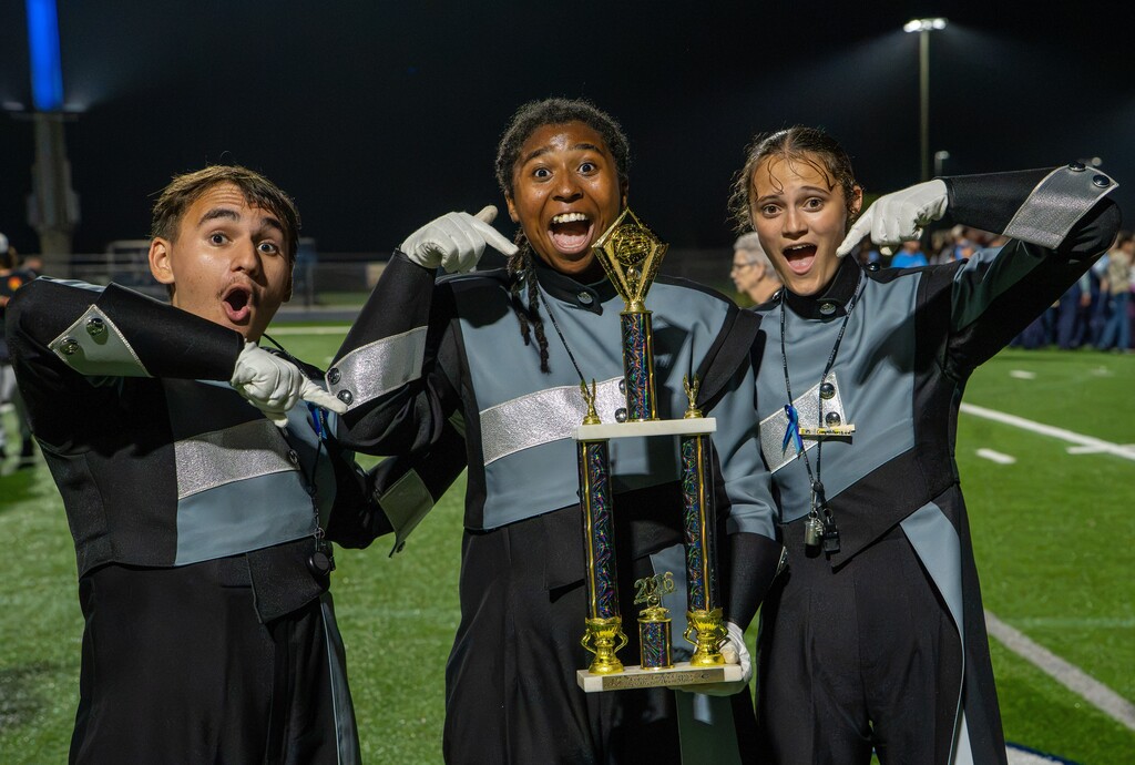 drum majors posing with trophies