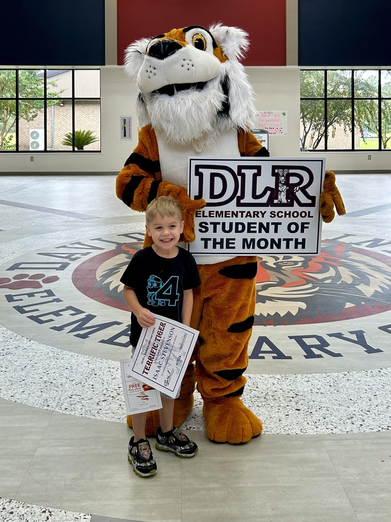 Boy standing with Tiger mascot holding a sign that says "DLR Elementary School Student of the Month"