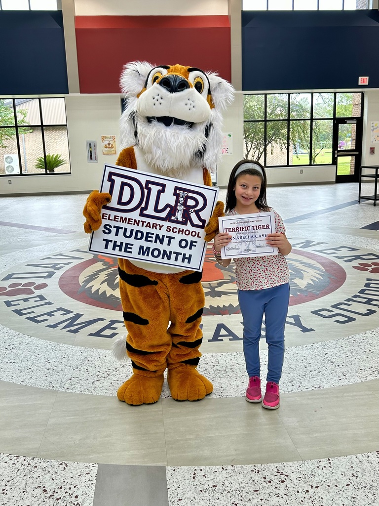 Girl standing with Tiger mascot holding a sign that says "DLR Elementary School Student of the Month"