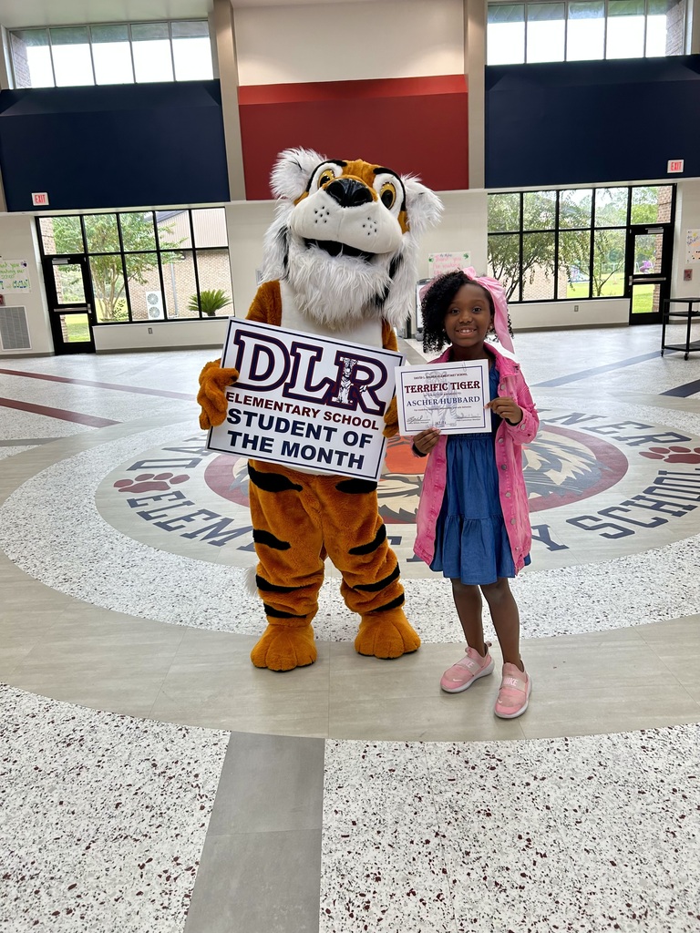 Girl standing with Tiger mascot holding a sign that says "DLR Elementary School Student of the Month"