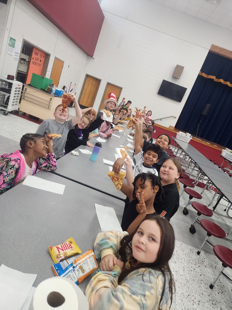 A group of 4th grade students enjoying pizza in the school cafeteria.
