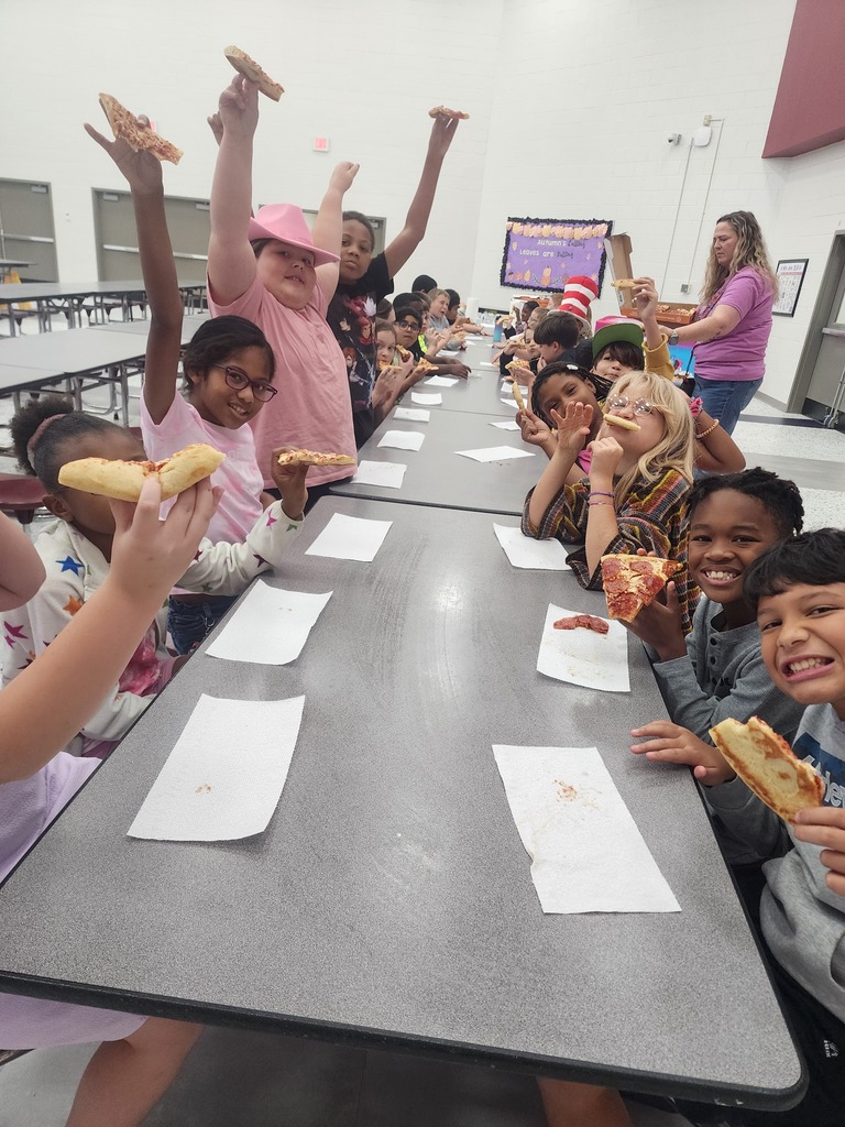 A group of 4th grade students enjoying pizza in the school cafeteria.