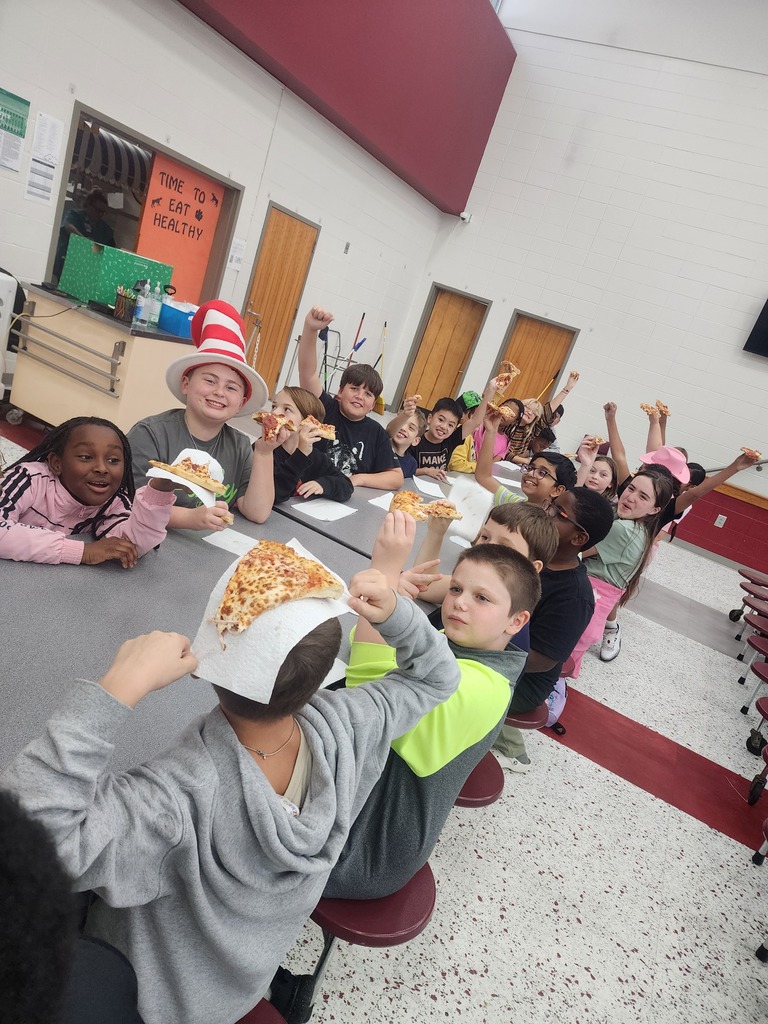 A group of 4th grade students enjoying pizza in the school cafeteria.