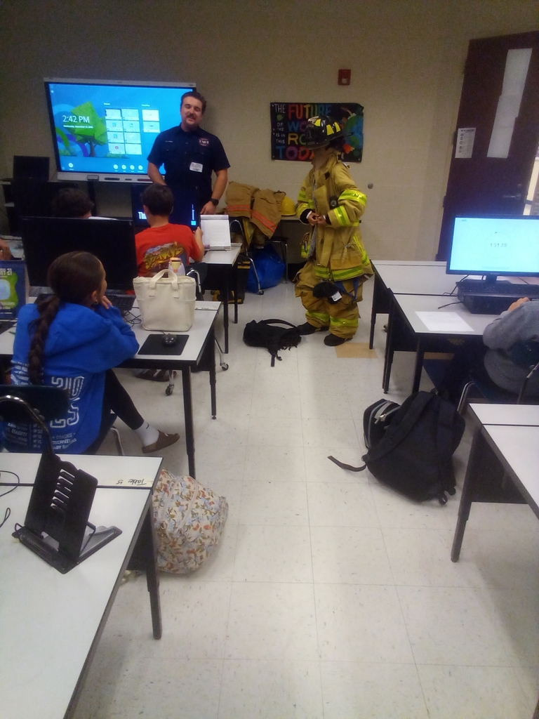 guest speaker and student trying on turnout gear