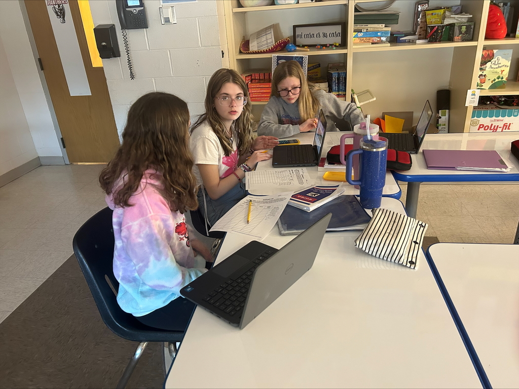 Three students working at their laptops together