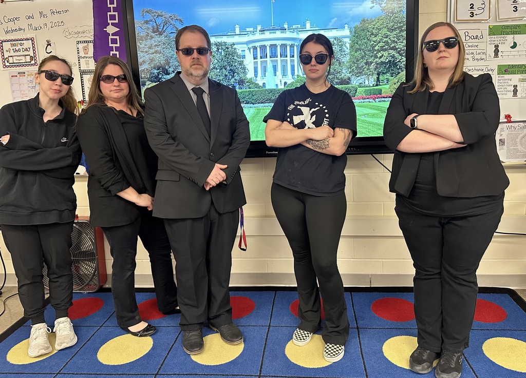 5 teachers posing in black wearing sunglasses