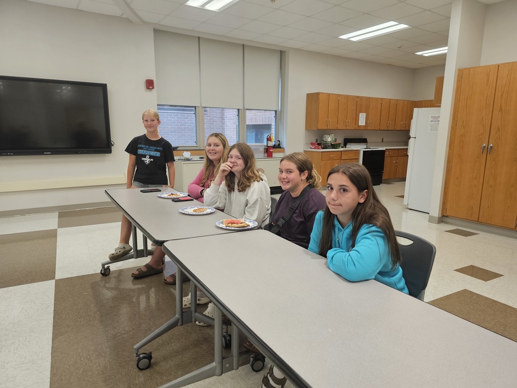 Student council members smiling at camera sitting at long table.