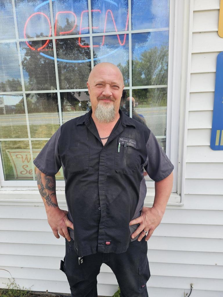 Dave smith standing in front of shop in work clothes