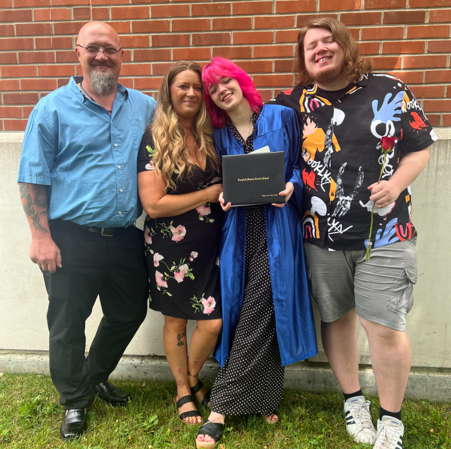 The Smith family posing at graduation with daughter in blue robe