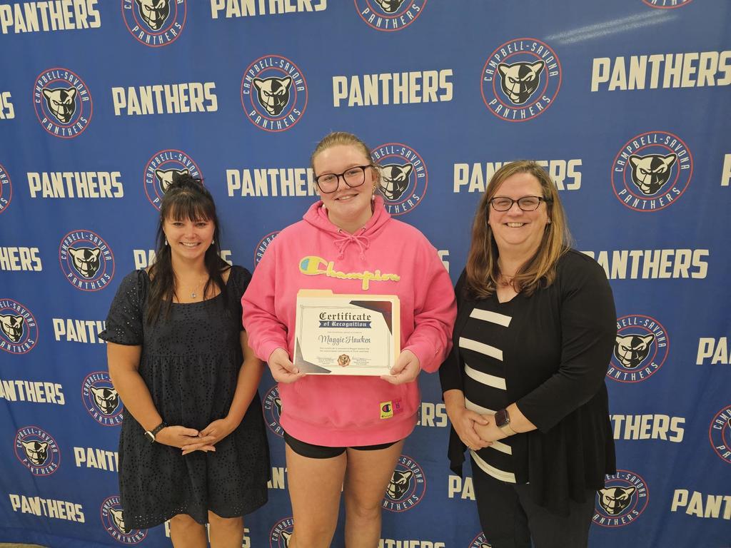BOE president and VP posing with student holding certificate in front of panther banner