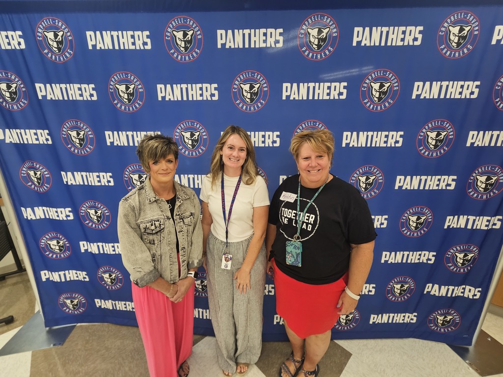 Three adults posing in front of panther banner