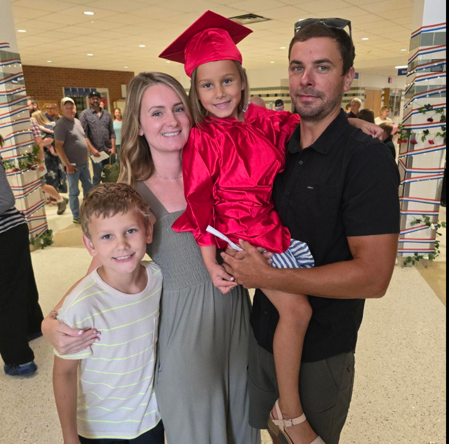 Family picture two children and two parents one child with red kindergarten graduation robe