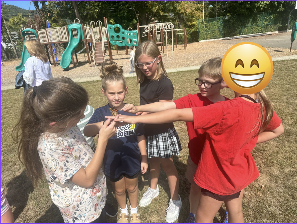 Group of 5 students  holding butterfly together
