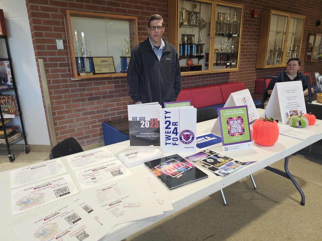 Yearbook club table picture with yearbooks and advisor