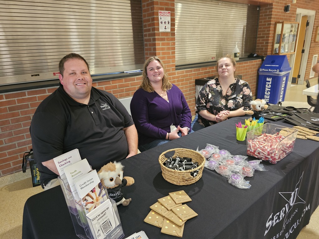 ServU Credit union information table at open house with three workers