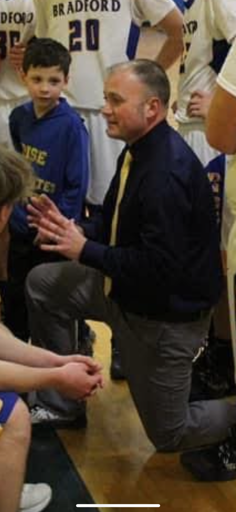 Basketball coach leaning in and talking to his players