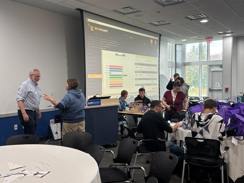 Room busy with kids and adults working on drones together