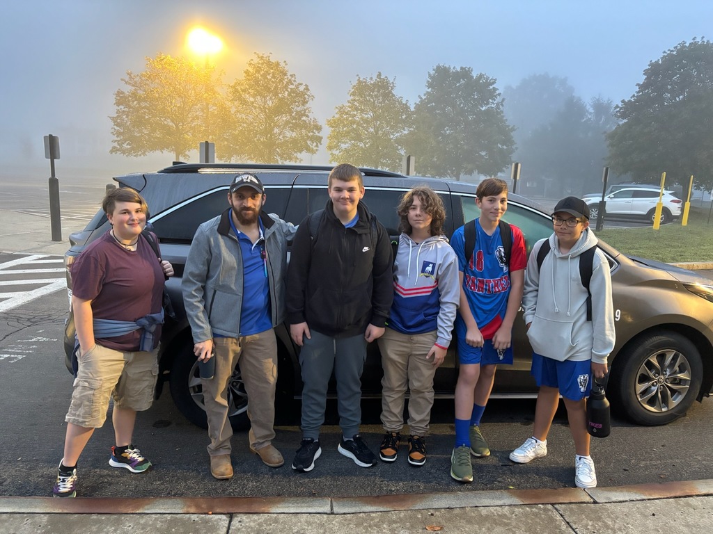 Group photo of students standing in front of the school van before leaving on field trip