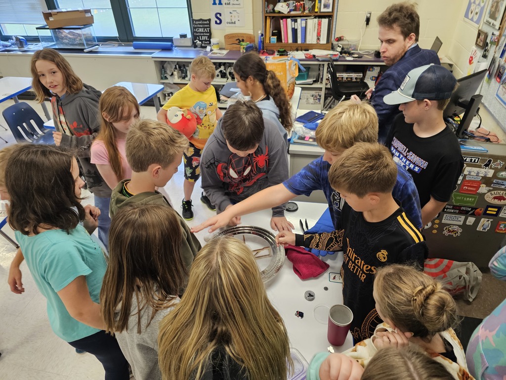 Students standing around a superconductor experiment with Dr. Vogt