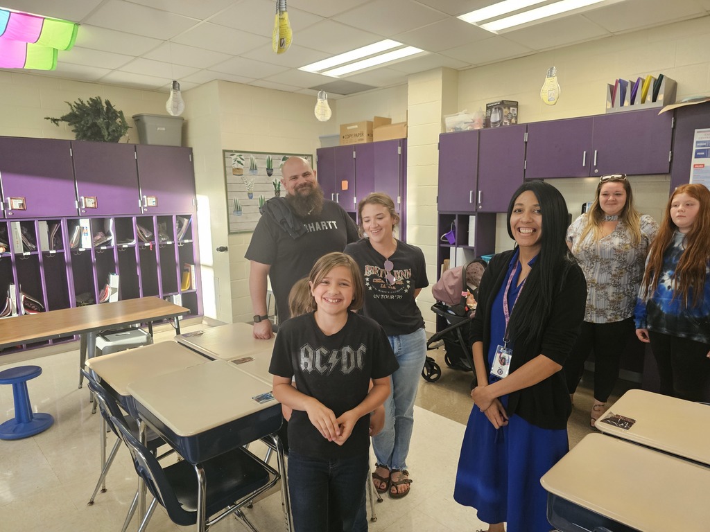 Family posing with teacher in classroom
