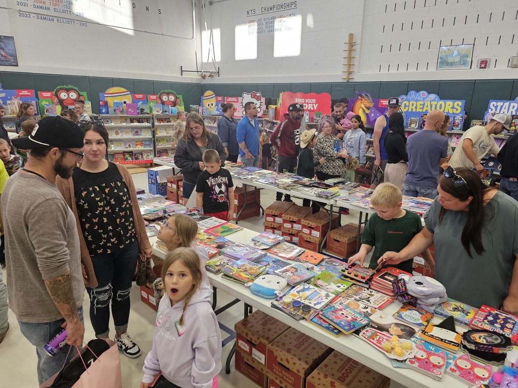 Wide view picture of the book fair with parents and students looking at books
