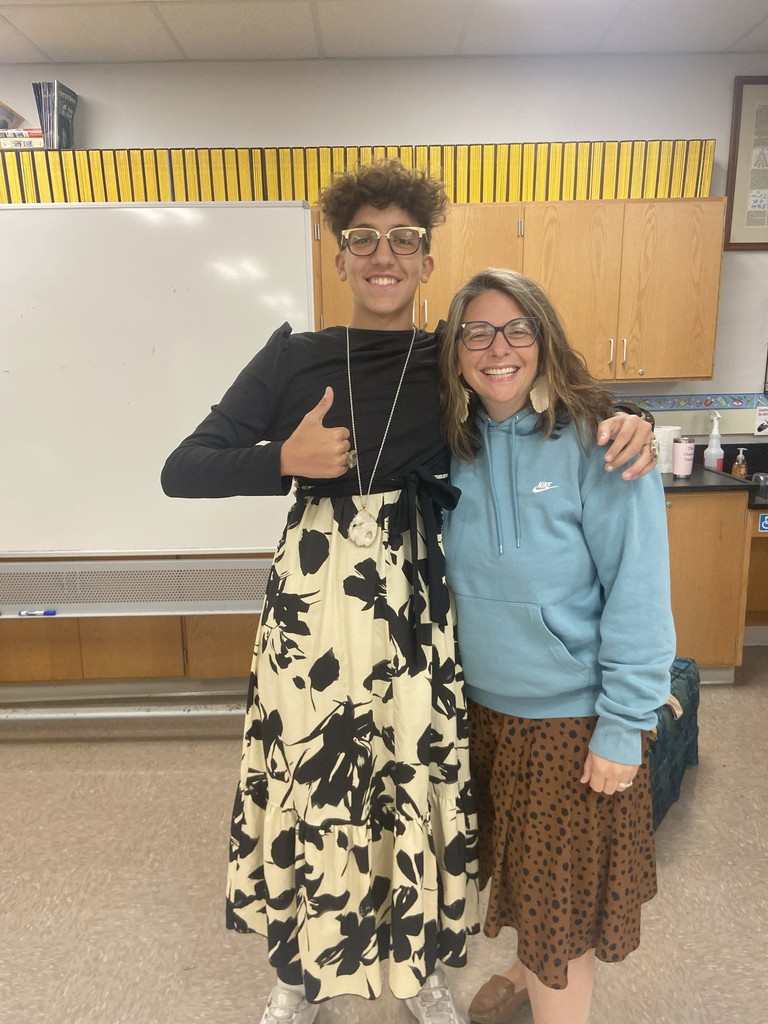 Student posing with a teacher in dress