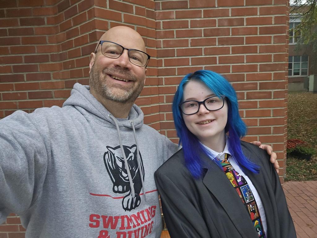 Student dressed in suit and tie with adult dressed as a kid in a sweatshirt