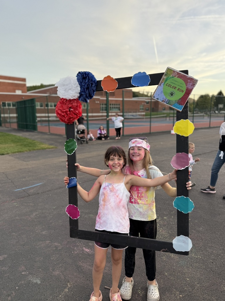 Students posing in a frame after color run with smiles
