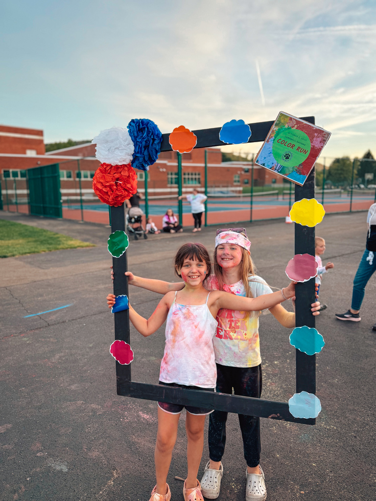 Students posing in a frame after color run with smiles