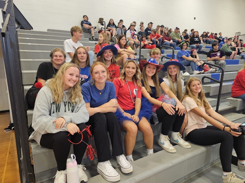 Group of students in school colors smiling at the pep assembly