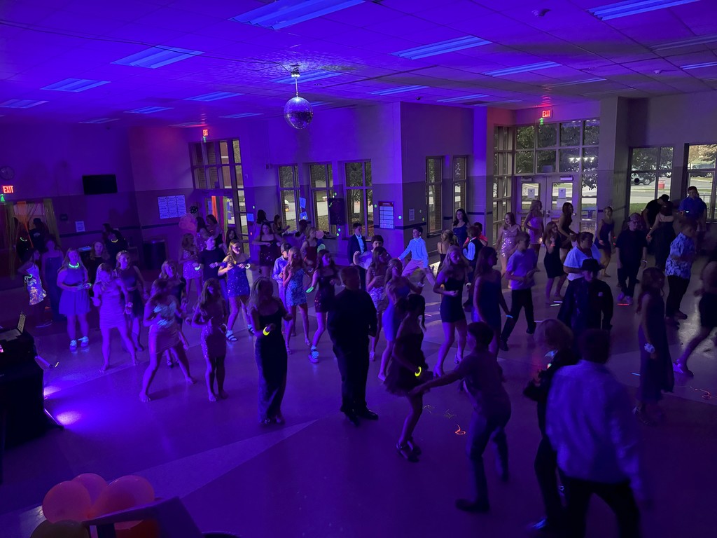 Wide shot photo of students dancing in a line at homecoming dance