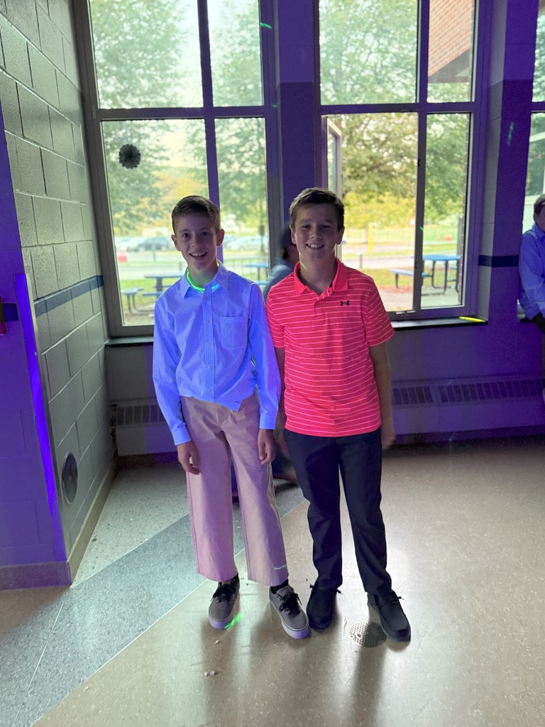 Two students posing in collored shirts for homecoming dance