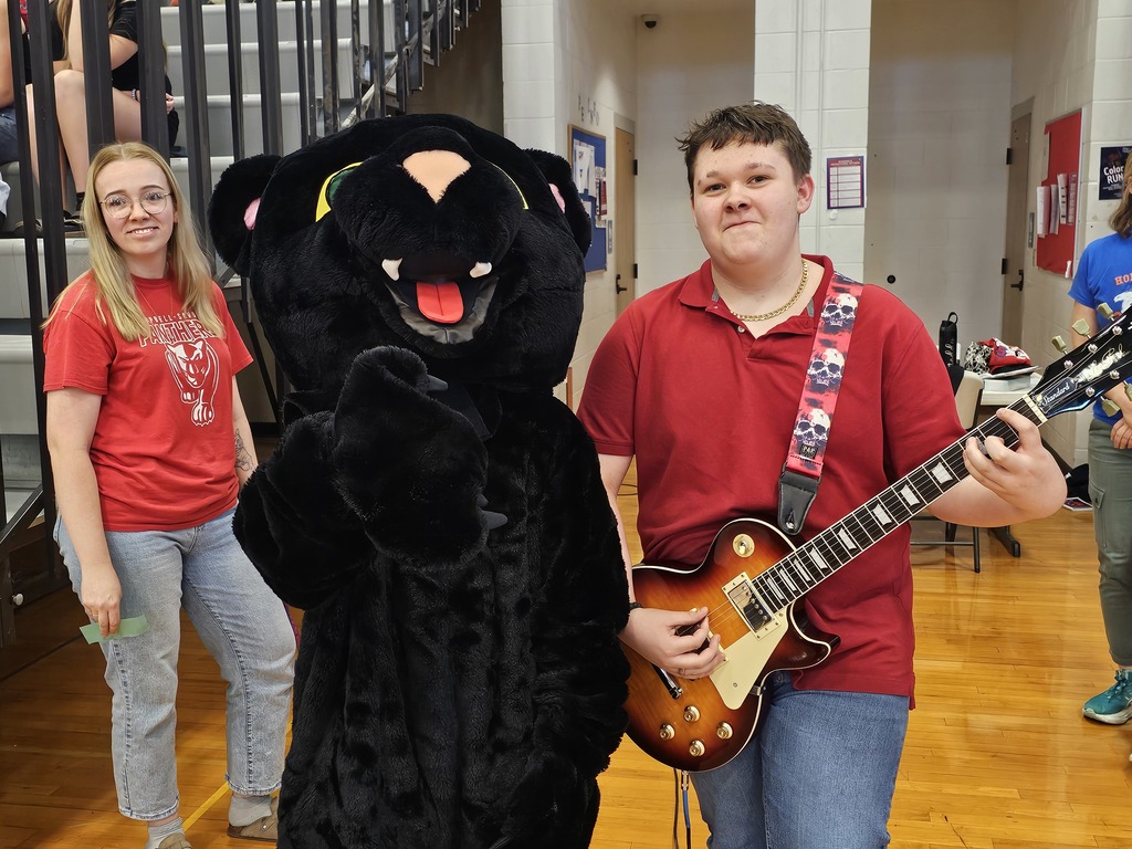 STudent with panther mascot posing with guitar
