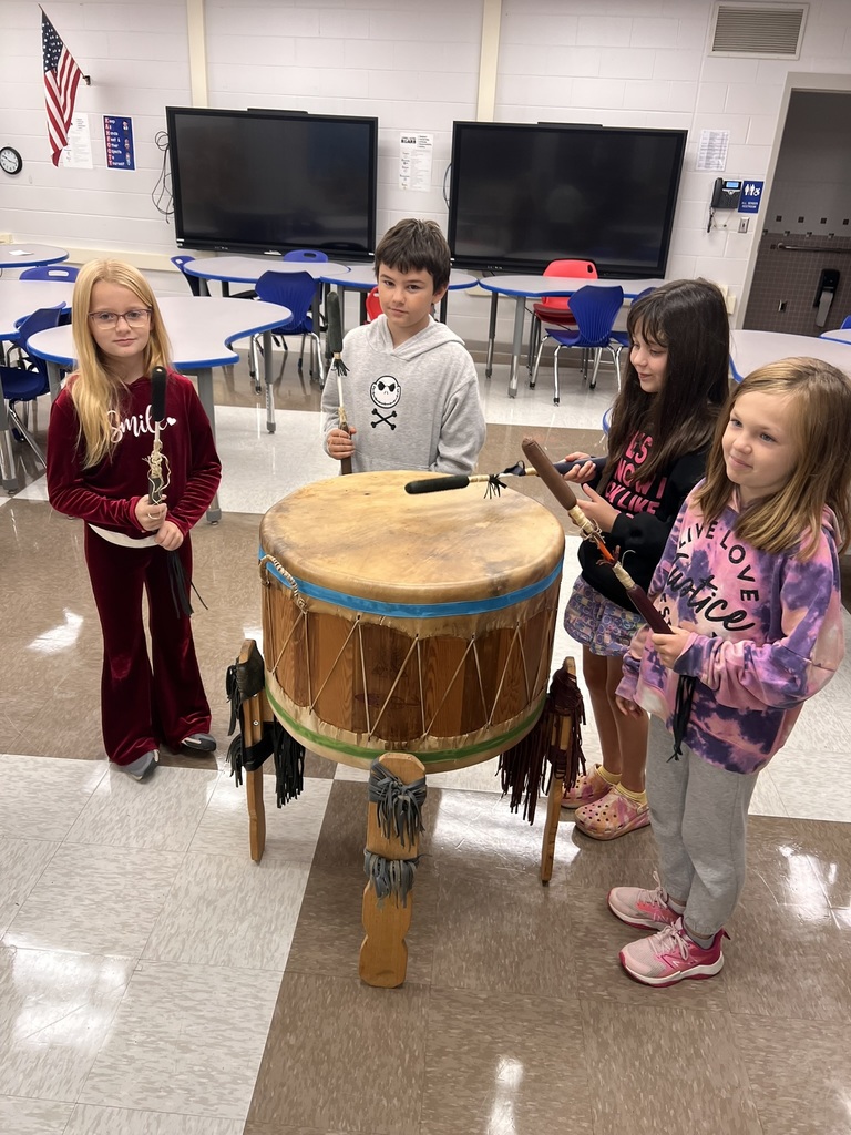 Students playing a big native american drum.