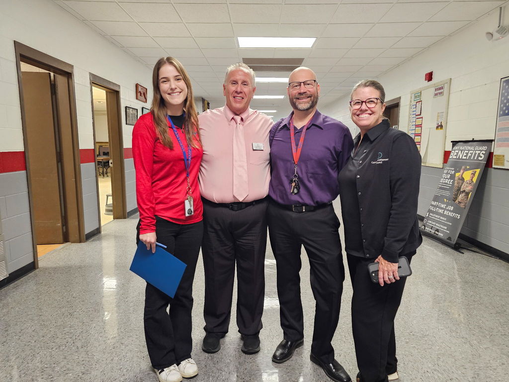 4 adults smiling for picture in business casual dress