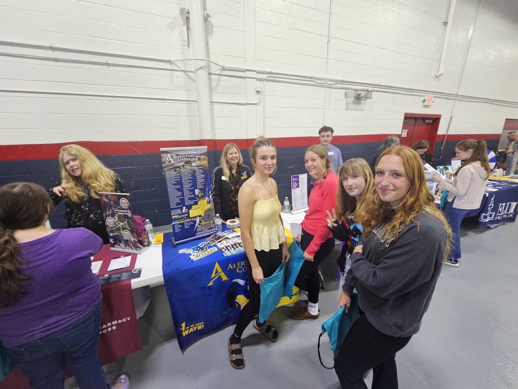 Students smiling standing at college information booth