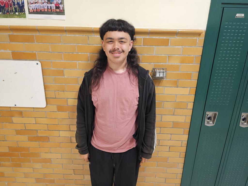 Student in salmon colored shirt with black zipper coat