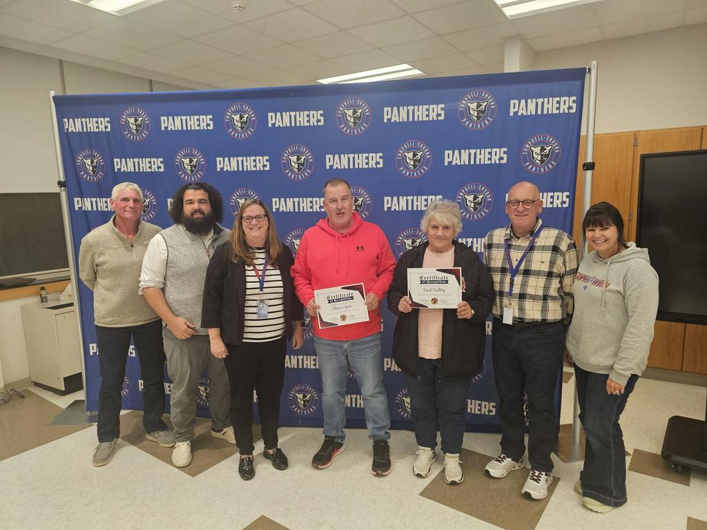 The board of education posing with two bus drivers holding certificates of recognition for safe driving.